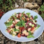 Sałatka z ugotowaną i pokrojoną ośmiornicą z dodatkiem cebuli, pomidorów oraz ziemniaka skropiona sosem winegret.