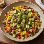 Sałatka z ryżem z dodatkiem tuńczyka, papryki, czerwonej fasolki i ogórków kiszonych z sosem z jogurtu, majonezu i curry.