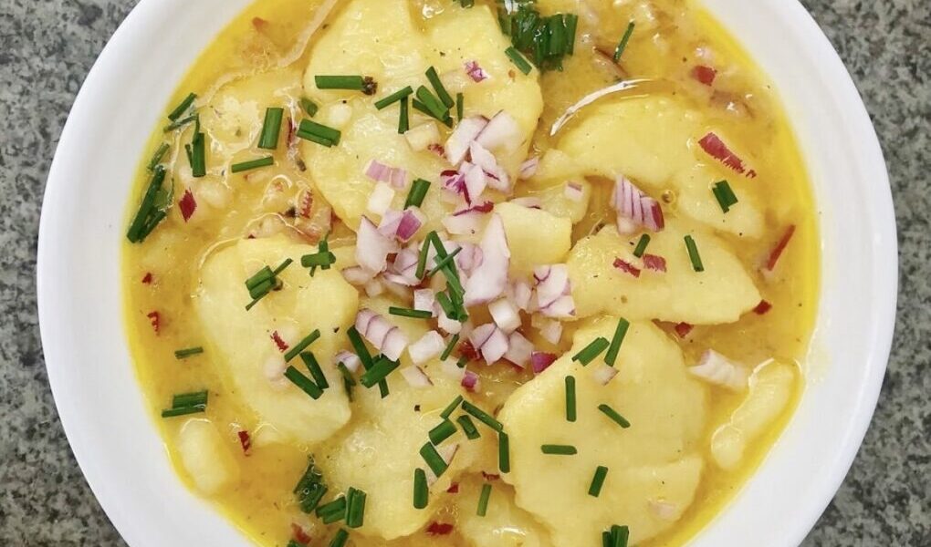 Sałatka ziemniaczana na kwaśno, czyli sałatka przygotowana z ziemniaków z dodatkiem bulionu, siekanej czerwonej cebuli, octu winnego, musztardy i oleju roślinnego.