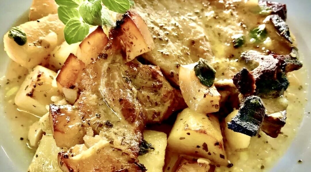 Kotlet schabowy marynowany w oliwie, musztardzie, czosnku i oregano, a następnie pieczony razem z ziemniakami.