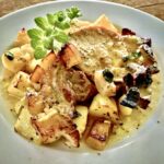 Kotlet schabowy marynowany w oliwie, musztardzie, czosnku i oregano, a następnie pieczony razem z ziemniakami.