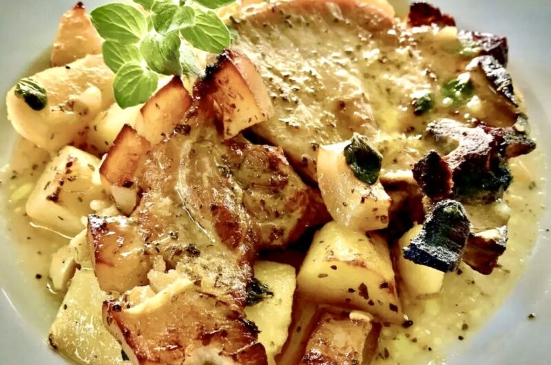 Kotlet schabowy marynowany w oliwie, musztardzie, czosnku i oregano, a następnie pieczony razem z ziemniakami.