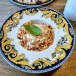 Spaghetti amatriciana, czyli spaghetti pochodzące z włoskiego miasta Amatrice, z aksamitnym sosem pomidorowym przygotowanym na aromatycznym podgardlu wieprzowym i posypane startym serem owczym pecorino.
