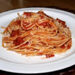Spaghetti amatriciana, czyli spaghetti pochodzące z włoskiego miasta Amatrice, z aksamitnym sosem pomidorowym przygotowanym na aromatycznym podgardlu wieprzowym i posypane startym serem owczym pecorino.