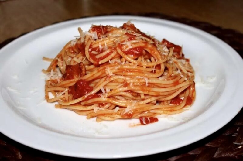 Spaghetti amatriciana, czyli spaghetti pochodzące z włoskiego miasta Amatrice, z aksamitnym sosem pomidorowym przygotowanym na aromatycznym podgardlu wieprzowym i posypane startym serem owczym pecorino.