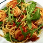 Makaron spaghetti ze smażonymi z czosnkiem i chilli krewetkami, pomidorami i świeżą rukolą.