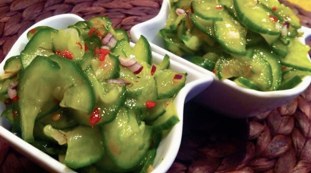 Surówka z ogórka po tajsku to pokrojone w cienkie plasterki świeże ogórki połączone z cebulą i chili, a następnie doprawione cukrem i octem ryżowym.