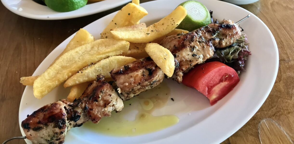 Szaszłyki wieprzowe czyli kawałki mięsa przyrządzone na grillu przyprawione oregano i skropione sokiem z cytryny tuż przed podaniem