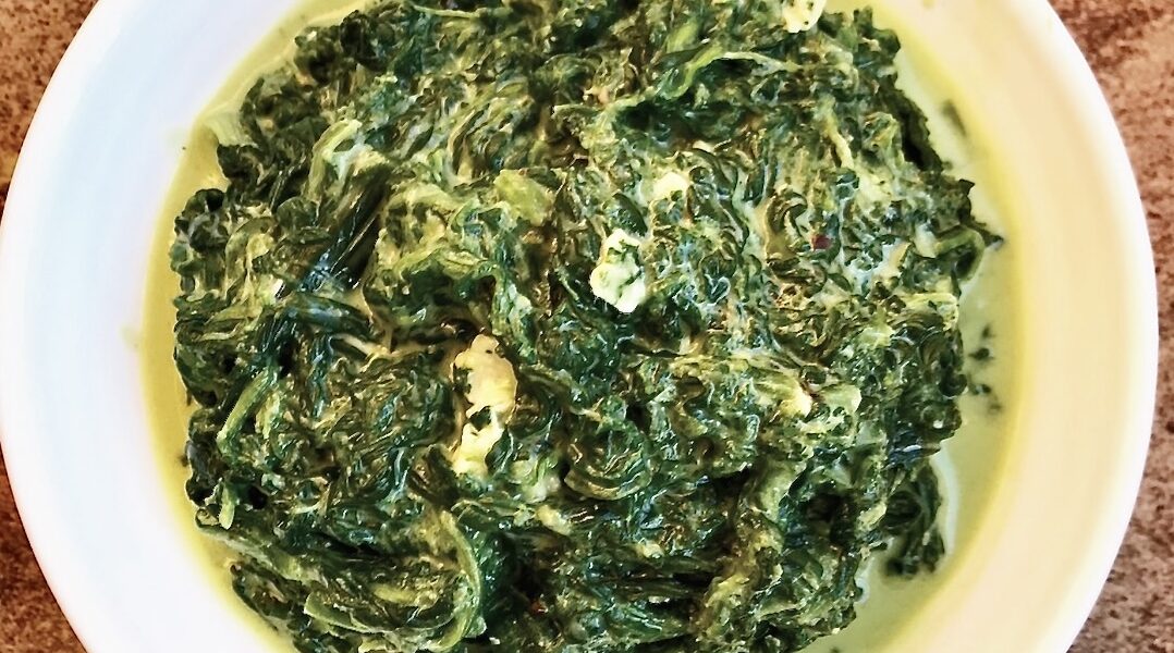 Szpinak w postaci liści duszony na gęsto na maśle z dodatkiem kwaśnej śmietany i z serem pleśniowym.