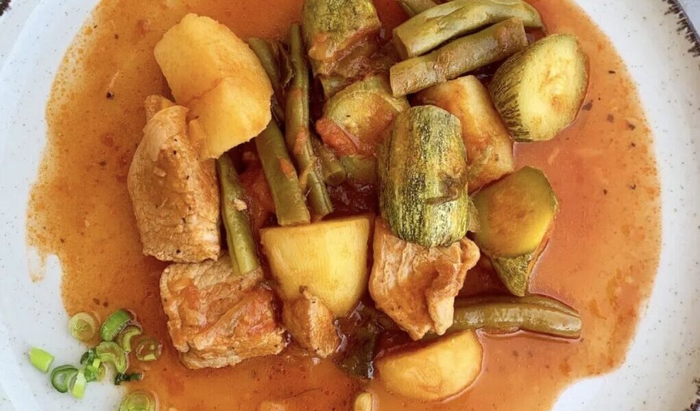 Szynka wieprzowa duszona, czyli kawałki wieprzowiny duszone razem z fasolką szparagową, cukinią, ziemniakami, marchewką i startym pomidorem.