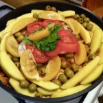 Tażin z kurczaka przygotowany został z kurczaka najpierw podzielonego na kawałki i marynowanego w chermouli, a następnie duszonego z dodatkiem ziemniaków, oliwek, cebuli i pomidorów.