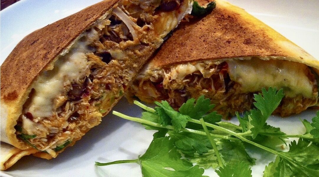 Tortilla z ugotowanym wcześniej kurczakiem z dodatkiem cebuli i czerwonej fasolki, a następnie zawinięta ze startym serem i kolendrą.