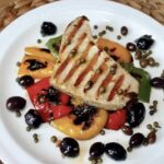 Pieczony na ruszcie tuńczyk z grilla podany z warzywami grillowanymi skropionymi oliwą.