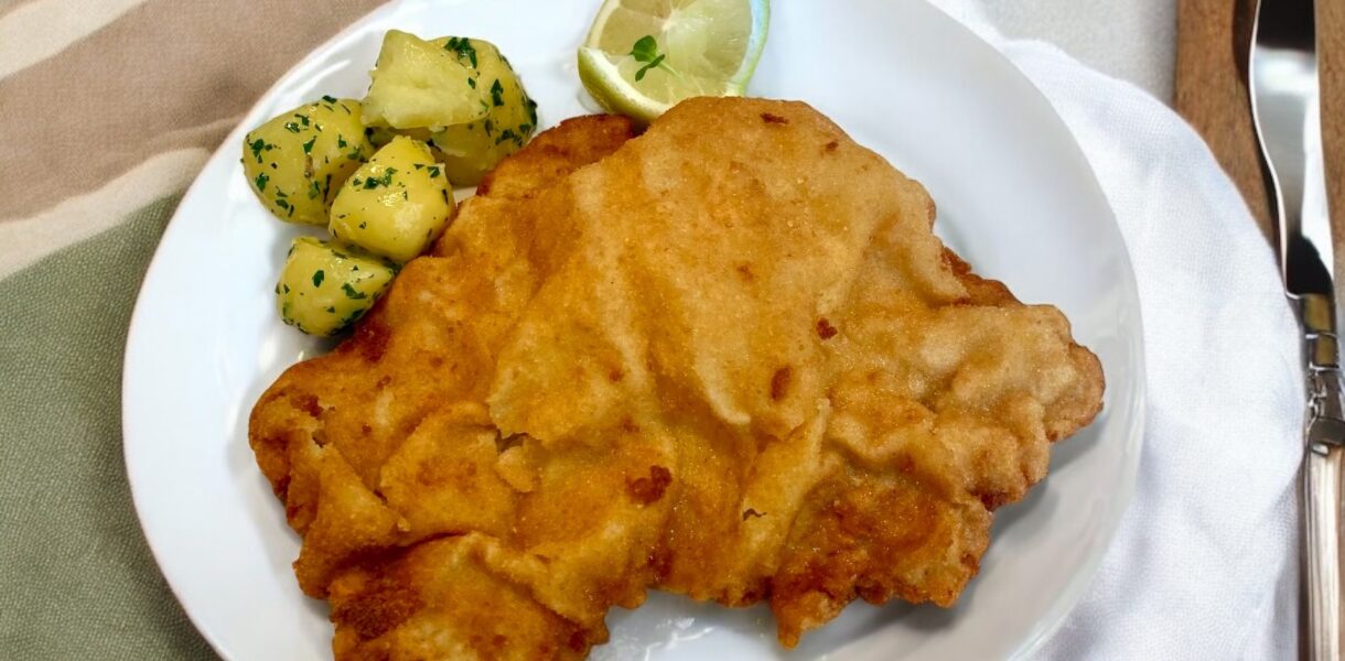 Wiener schnitzel na talerzu czyli panierowany kotlet cielęcy z Austrii. Przygotowuje się go w posobny sposób, jak polskiego kotleta schabowego.