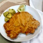 Wiener schnitzel na talerzu czyli panierowany kotlet cielęcy z Austrii. Przygotowuje się go w posobny sposób, jak polskiego kotleta schabowego.