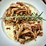 Wieprzowina długo pieczona pozostała z dnia poprzedniego przygotowana z czosnkiem i rozmarynem z dodatkiem sosu pieczeniowego.