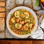 Wieprzowina w kawałkach smażona na oliwie, a następnie duszona z groszkiem i ziemniakami oraz startymi pomidorami.