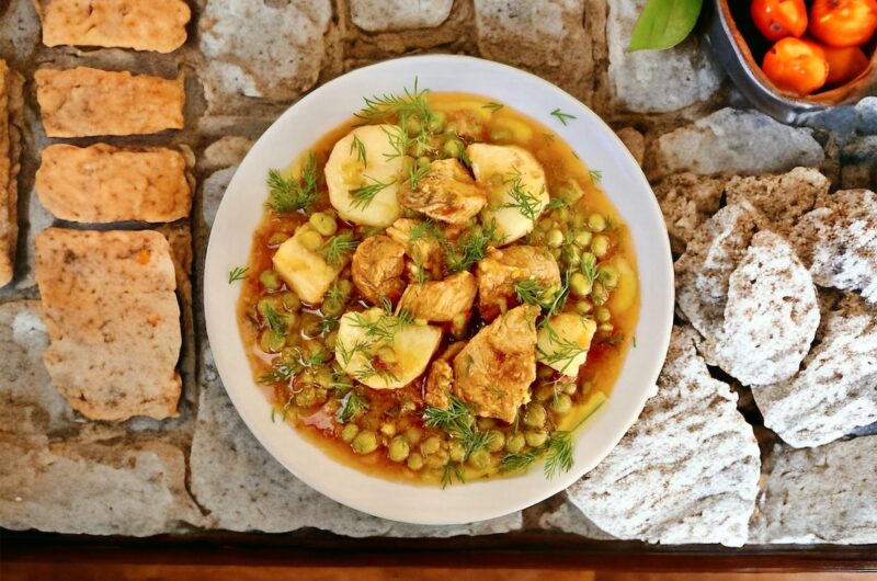 Wieprzowina w kawałkach smażona na oliwie, a następnie duszona z groszkiem i ziemniakami oraz startymi pomidorami.