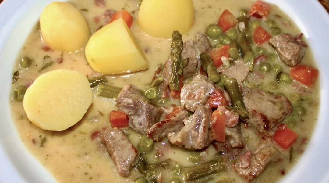 Gulasz cielęcy z mięsa krojonego w kostkę, a następnie duszonego z szynką, marchewką i szparagami na koniec doprawiony słodką śmietanką.