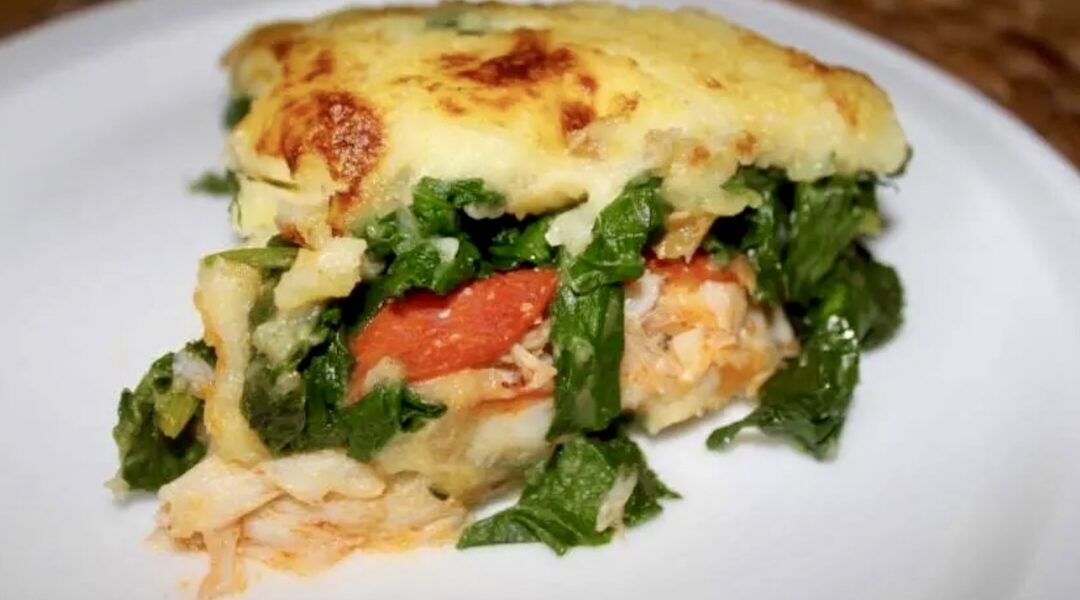 Zapiekanka z dorszem gotowanym bacalhao z puree ziemniaczanym, kiełbasą chorizo i liśćmi szpinaku.