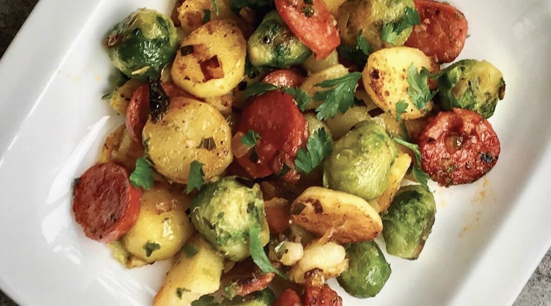 Ziemniaki pozostałe z poprzedniego dnia pokrojone na plastry, a następnie smażone z pokrojoną kiełbasą i brukselką.