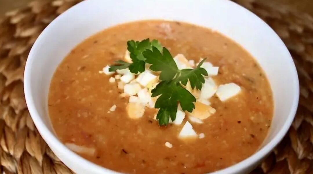 Zupa fasolowa z białej fasolki gotowana na bazie wędzonego boczku i ryżu z dodatkiem pomidorów i czosnku.