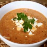 Zupa fasolowa z białej fasolki gotowana na bazie wędzonego boczku i ryżu z dodatkiem pomidorów i czosnku.