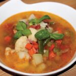 Zupa minestrone, czyli włoska zupa jarzynowa w wersji zimowej przygotowana na domowym bulionie drobiowym zrobiona na soffritto i z dodatkiem mrożonych warzyw.