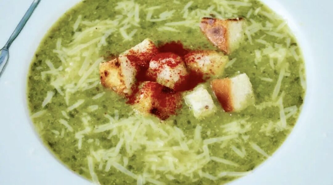 Zupa pietruszkowa przygotowana na bulionie jarzynowym z dodatkiem wielkiego pęczka natki pietruszki, dymki i selera naciowego podana z domowymi grzankami z chleba.