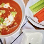 Zupa pomidorowa na bulionie drobiowym z dodatkiem fenkuła, startych pomidorów, ciecierzycy oraz ostrej papryczki chipotle przygotowana na ostro.