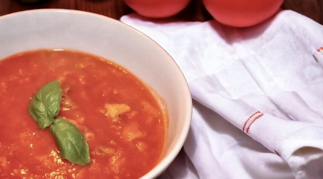Zupa pomidorowa na wywarze jarzynowym z dodatkiem domowego przecieru pomidorowego i świeżej bazylii podana z lanym ciastem.