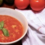 Zupa pomidorowa na wywarze jarzynowym z dodatkiem domowego przecieru pomidorowego i świeżej bazylii podana z lanym ciastem.