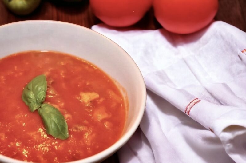 Zupa pomidorowa na wywarze jarzynowym z dodatkiem domowego przecieru pomidorowego i świeżej bazylii podana z lanym ciastem.