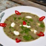 Zupa porowa na wywarze drobiowym przyrządzona z soczewicą i porem przesmażonym na maśle oraz z zielonym groszkiem.