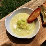 Zupa porowa przygotowana z krojonych i przesmażonych na maśle porów z dodatkiem ziemniaków i mleka, zmiksowana i podawana z grzankami.