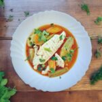 Zupa rybaka przygotowana na bazie wywaru rybnego podawana z warzywami i świeżą doradą.