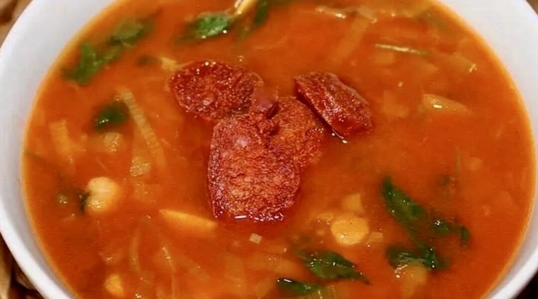 Zupa z porem na bulionie warzywnym przygotowana z dodatkiem przesmażonego z kminem rzymskim pora oraz z ciecierzycą i chrupiącymi plastrami smażonej kiełbasy chorizo.