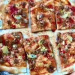 Flammkuchen to podpłomyk zrobiony z mąki i wody pieczony krótko w bardzo wysokiej temperaturze razem z mięsem mielonym, czosnkiem i chilli.