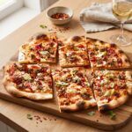 Flammkuchen to podpłomyk zrobiony z mąki i wody pieczony krótko w bardzo wysokiej temperaturze razem z mięsem mielonym, czosnkiem i chilli.