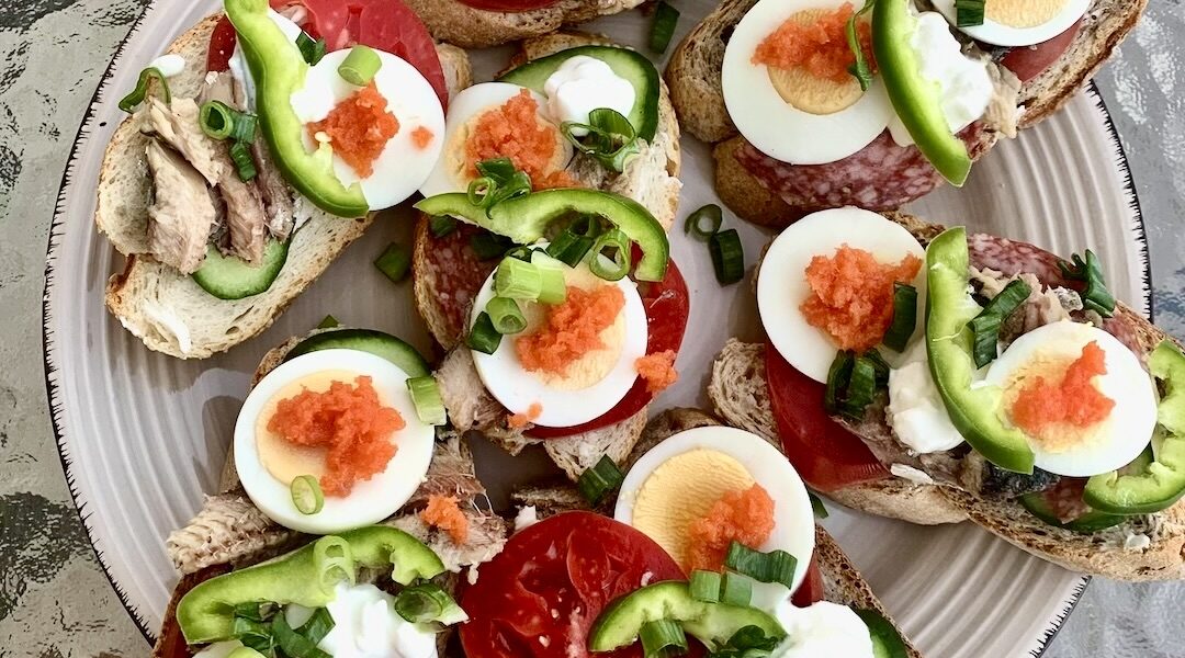 Kanapki na imprezę przygotowane na białym i ciemnym pieczywie, a obłożyłem je plastrami salami, sardynkami z puszki, gotowanymi jajkami, pomidorem, ogórkiem, papryką i innymi chrupiącymi warzywami.