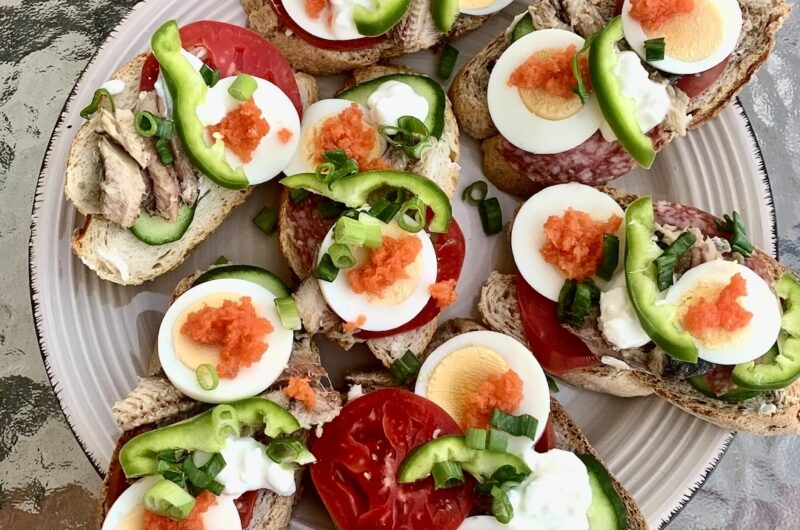 Kanapki na imprezę przygotowane na białym i ciemnym pieczywie, a obłożyłem je plastrami salami, sardynkami z puszki, gotowanymi jajkami, pomidorem, ogórkiem, papryką i innymi chrupiącymi warzywami.