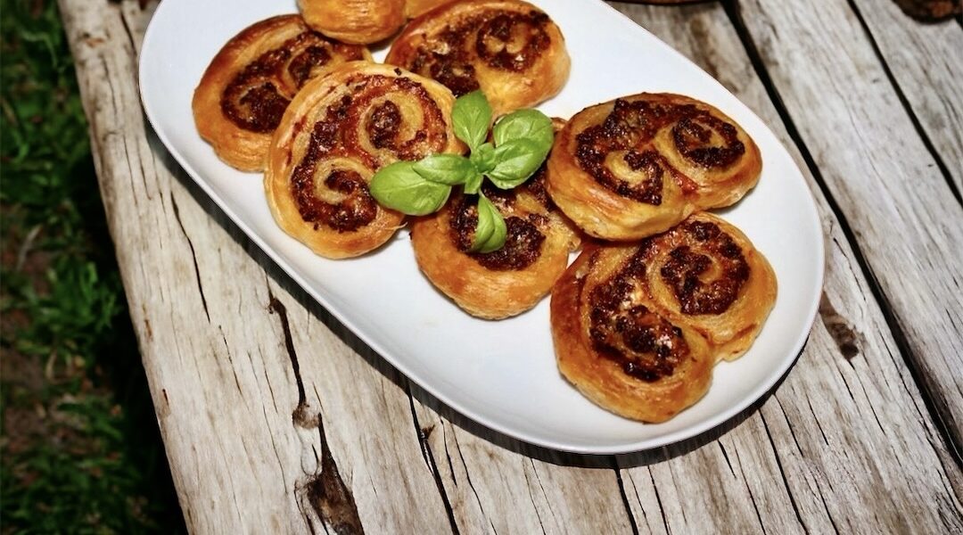 Palmiery na słono przygotowane z ciasta francuskiego wypełnionego zmiksowanymi oliwkami, salami, kaparami i suszonymi pomidorami, a następnie zawiniętego w rulon i pieczonego.