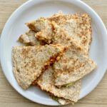 Quesadilla z tuńczykiem to tortilla obłożona tuńczykiem z puszki z dodatkiem startego sera, awokado i mozzarelli, a następnie przykryta drugą tortillą i podgrzana na patelni.