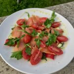 Sałatka łososiowa przygotowana z plasterków łososia wędzonego podanego z kawałkami awokado, z pomidorami koktajlowymi i czerwoną papryka. Sałatka przed podaniem skropiona została oliwą extra vergine i sokiem z cytryny.