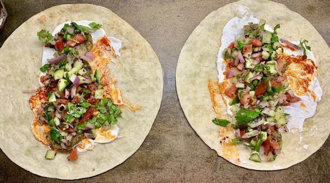 Wrapy czyli tortille wypełnione falafelami kotlecikami z ciecierzycy, krojonymi warzywami, gęstym jogurtem i sosem sambal, a następnie zawijane i podgrzewane.