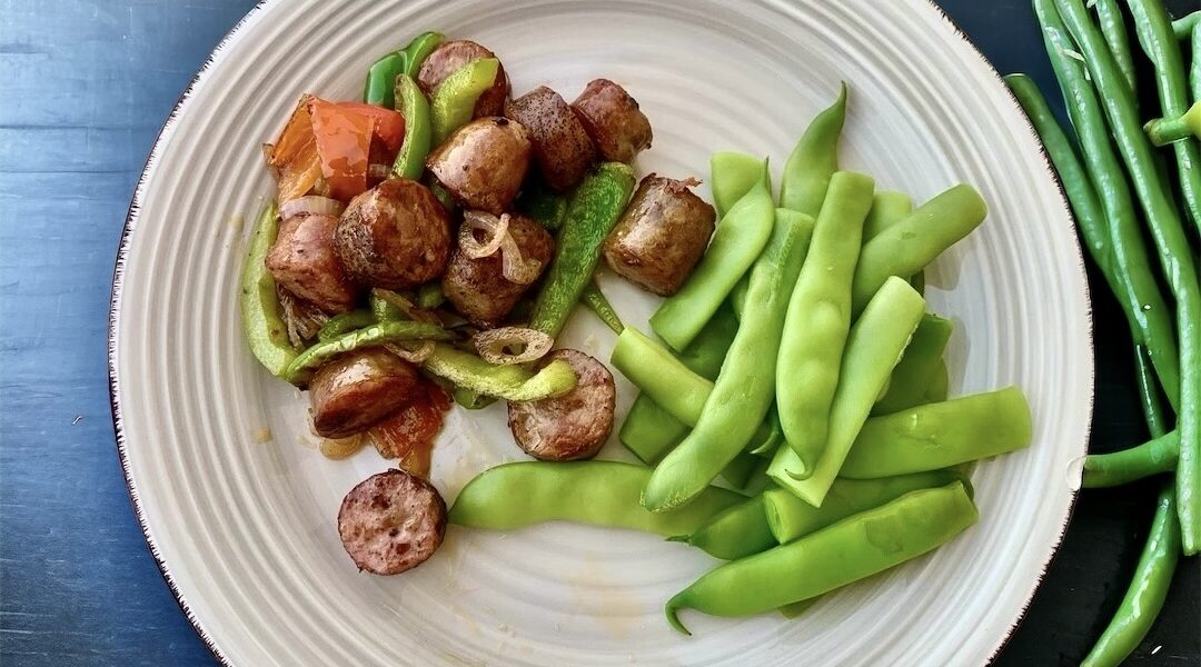 Cienkie białe kiełbaski krojone w małe kawałki, a następnie smażone z paskami świeżych papryk oraz cebulą, z dodatkiem pasaty pomidorowej.