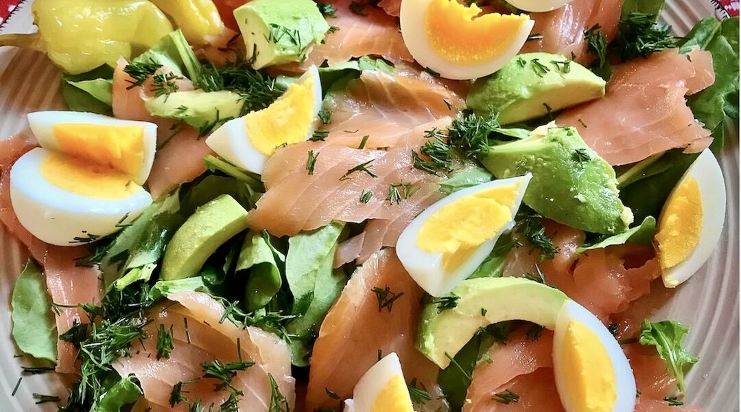Sałatka z dojrzałym i miękkim awokado oraz z łososiem wędzonym na zimno, wzbogacona gotowanym jajkiem oraz rukolą skropiona tuż przed podaniem oliwą i sokiem z cytryny.