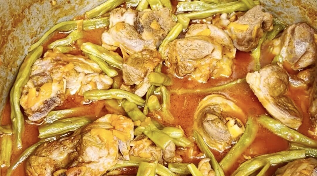 Jagnięcina z kością pokrojona na kawałki duszona wolno w pomidorach z zieloną fasolką szparagową.