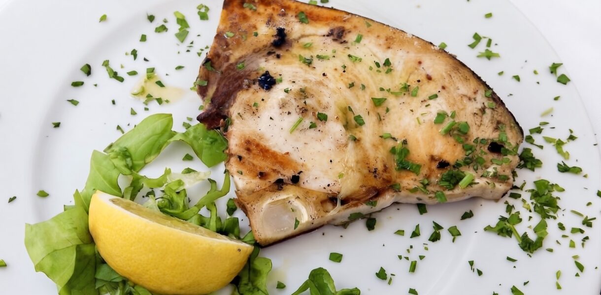 miecznik z grilla (stek) w sosie vinegrette na talerzu