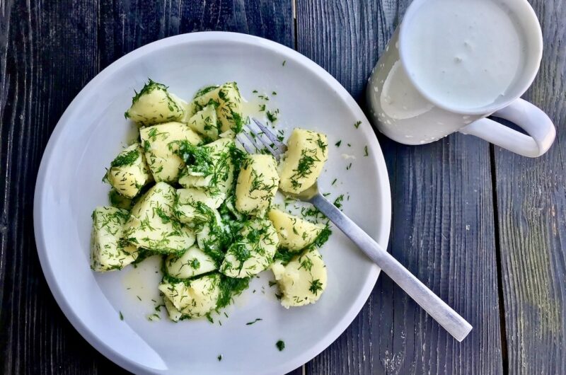Młode ziemniaki gotowane, a następnie odcedzone i połączone z masłem i siekanym koperkiem serwowane z zimnym kefirem.